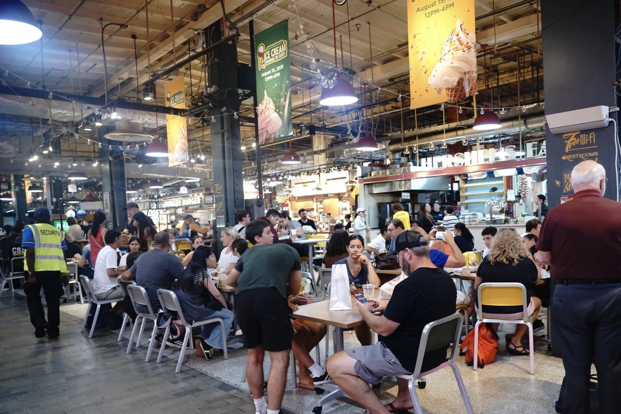 People sharing tables and moving through the crowded Reading Terminal Market