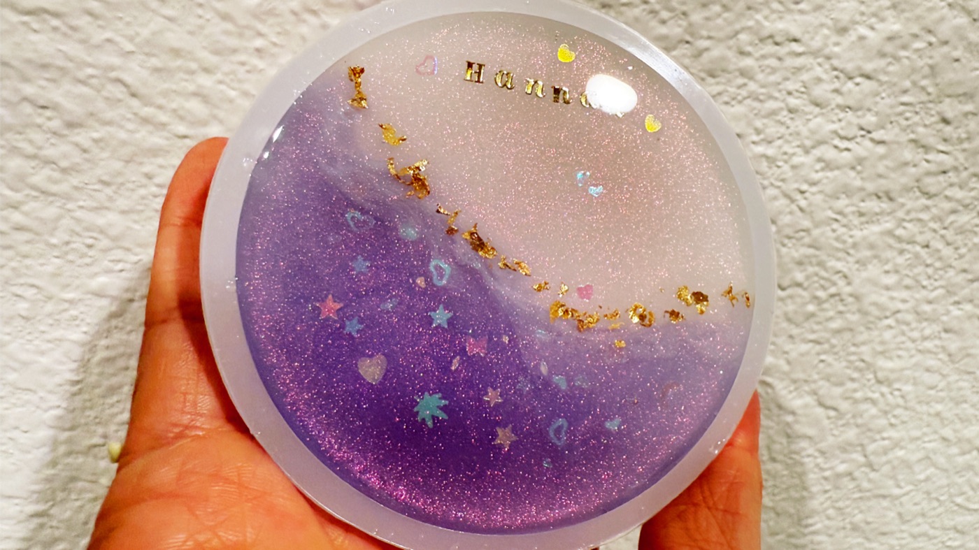 A personalized purple resin coaster made for a friend