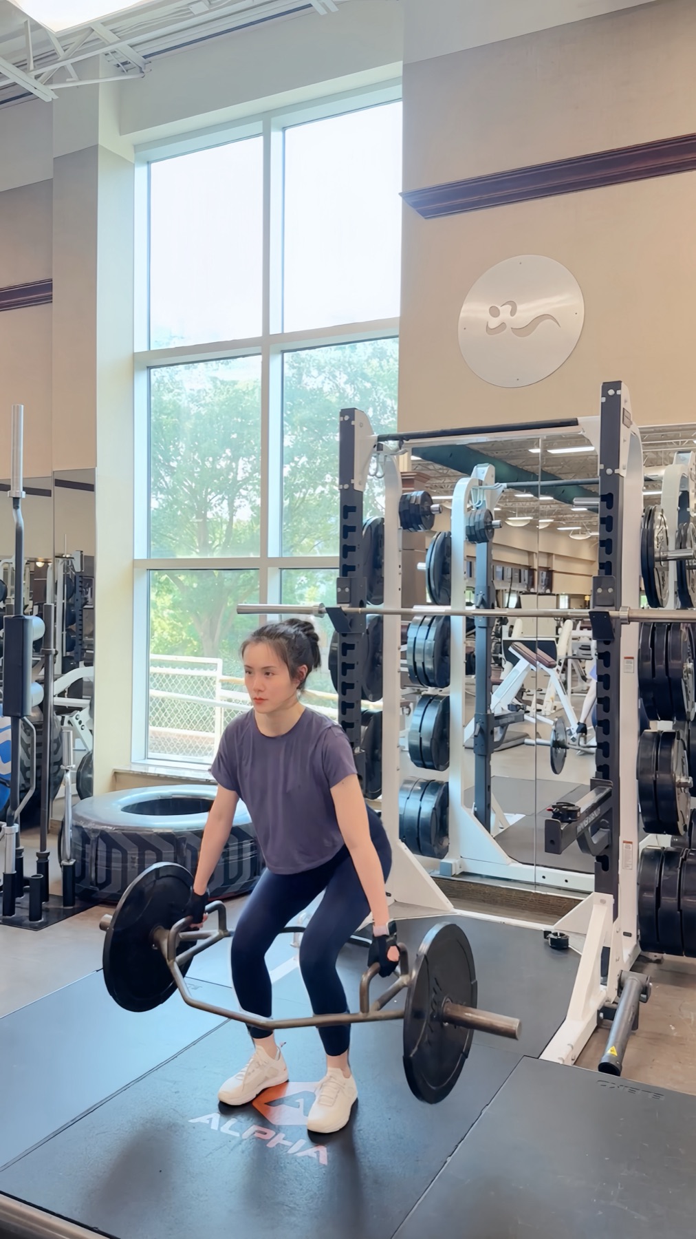 Kaia completing a trap bar deadlift at the gym